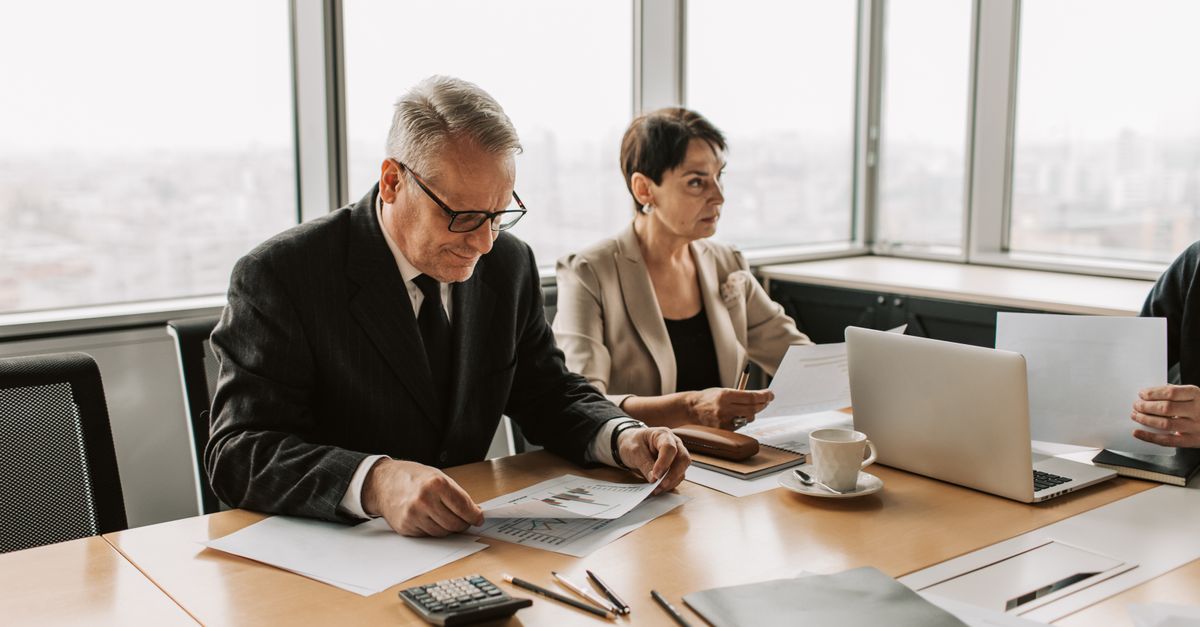 Corporate meeting with professionals discussing documents in a modern office.