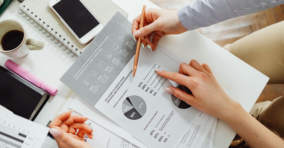 Team collaborating on financial documents with graphs and statistics in an office setting.