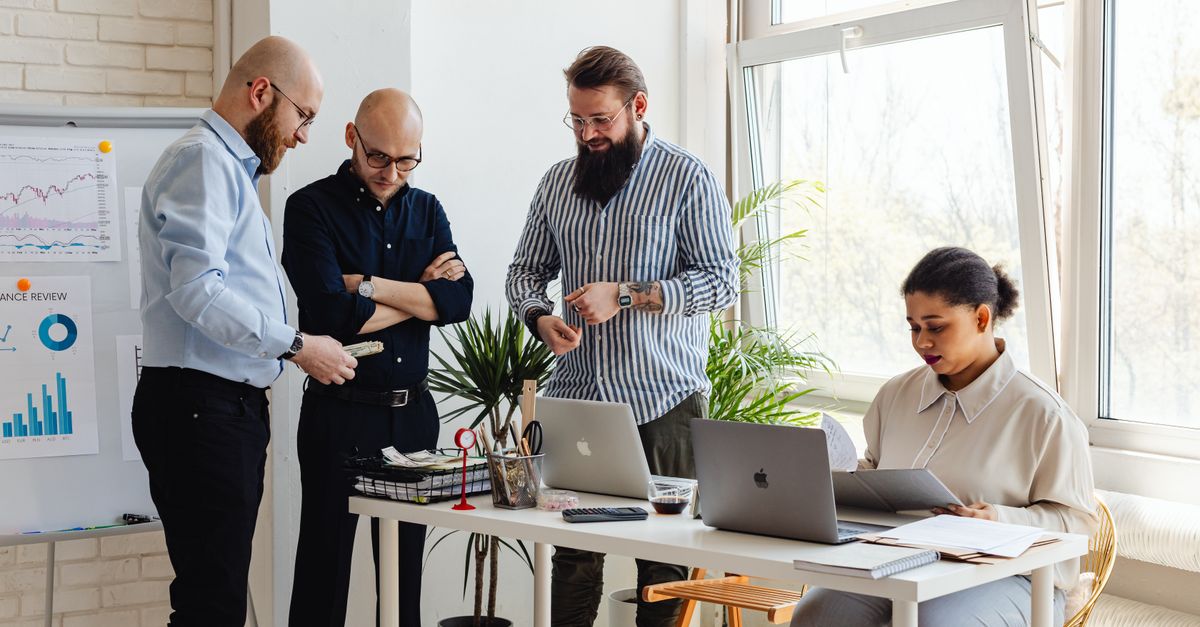 Business professionals collaborating on project in bright modern office space.